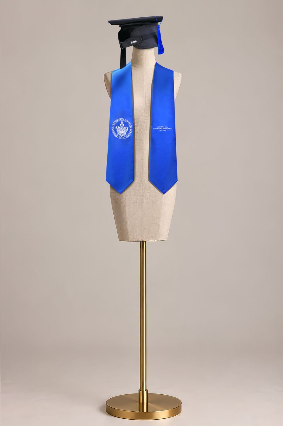 Maniquí con birrete negro y estola azul bordada con escudo.